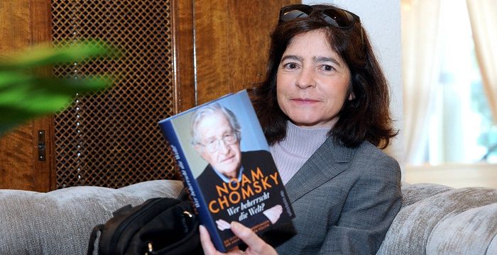 Valeria Wasserman holding the book written by Noam Chomsky