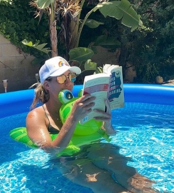 April Ross reading book in a pool
