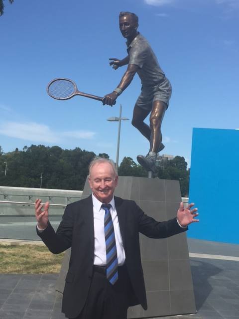 Rod Laver posing next to a statue of himself outside the Laver arena.