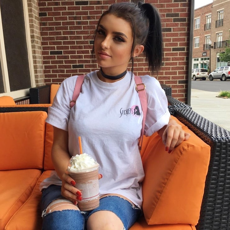 Shannon Bubb posing for a camera while having a milkshake