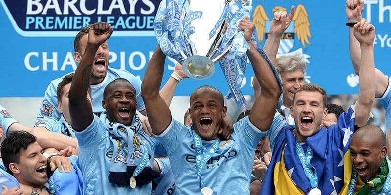 Manchester City team member holding a trophy