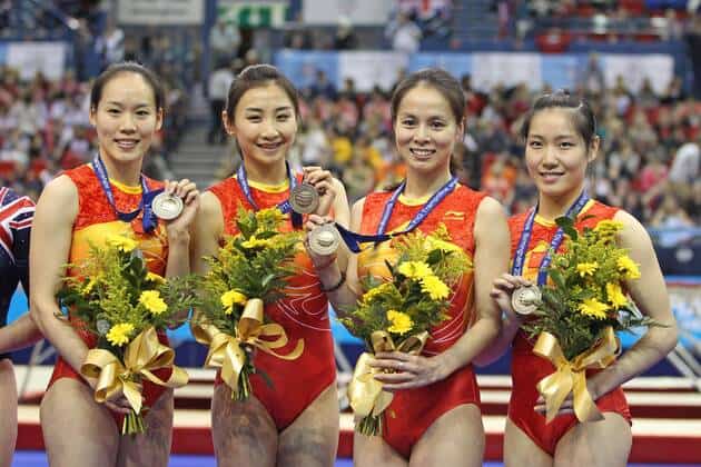 Huang Shanshan with her teammates posing with a gold medal.