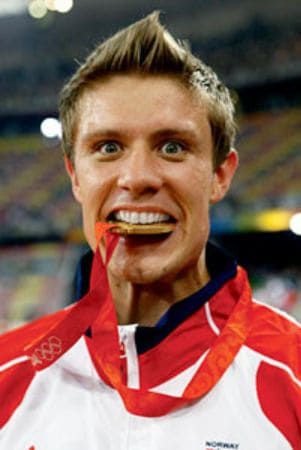 Andreas Thorkildsen biting his Gold Medal