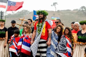 Actor Jason Momoa holds the hands of his children, Nakoa-Wolf Momoa, left, and Lola Momoa, right, as he is welcomed with a hula while visiting elders and Native Hawaiian protesters blocking the construction of a giant telescope on Hawaii's tallest mountain