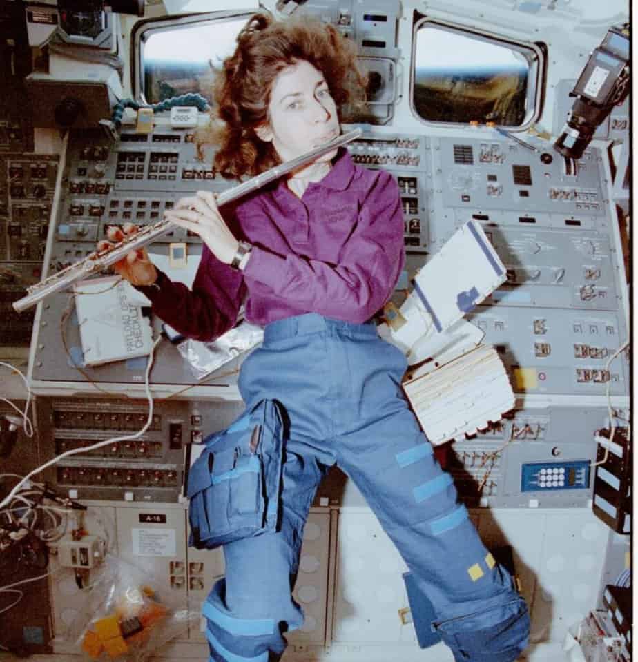 Candid view of Mission Specialist Ellen Ochoa, in the aft flight deck, playing a flute, Apr 17, 1993 